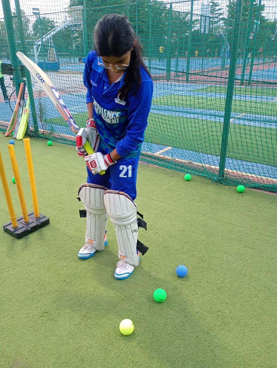 Cricket coach guiding a young player during training
